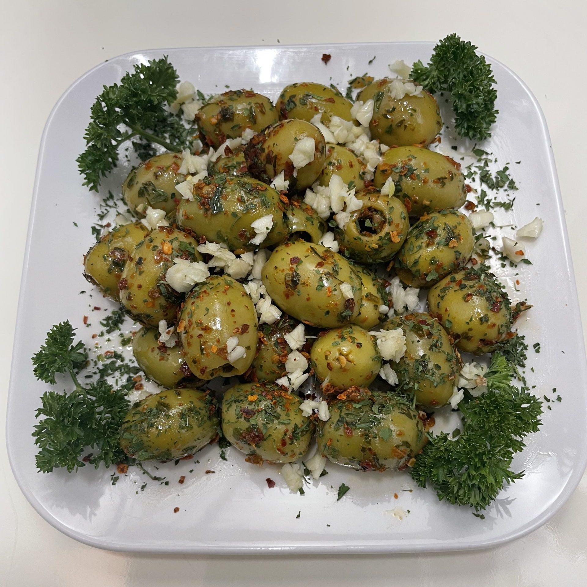 Grüne scharfe Oliven eingelegt in Knoblauch Kräütermarinade.JPG